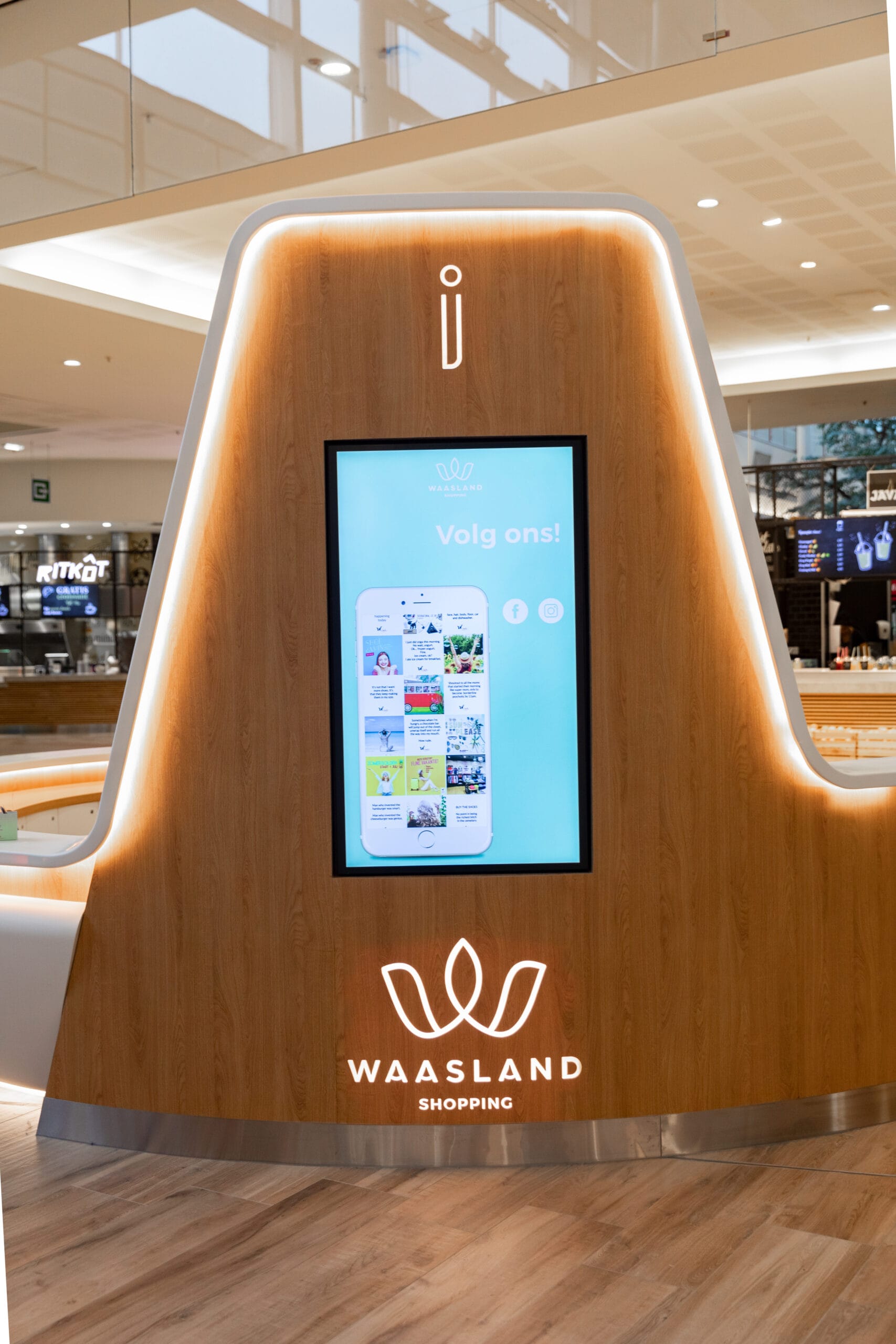 Redesigned information desk with panelled wood and neutral lighting &mdash; Waasland Shopping Centre, Belgium, Air Design